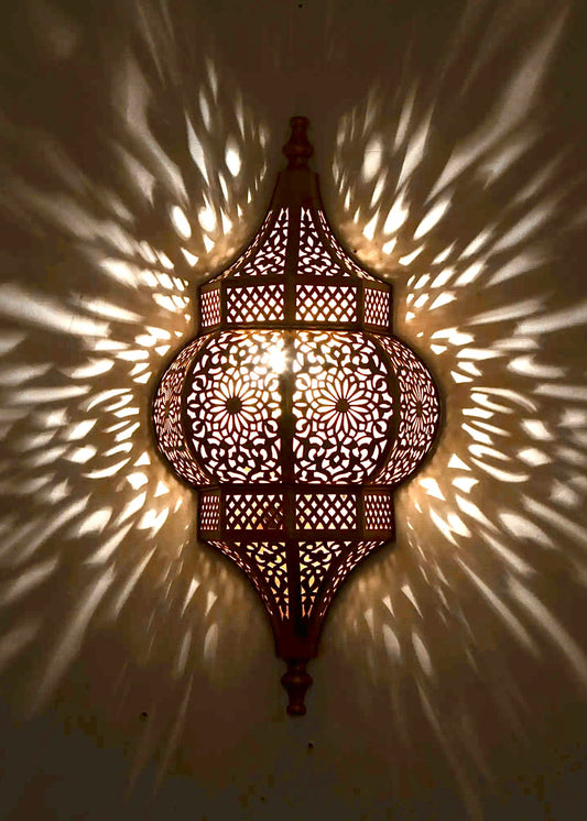 Close-up of the shadow pattern created by a Moroccan handmade brass wall lamp, showing the high-quality craftsmanship and light diffusion.