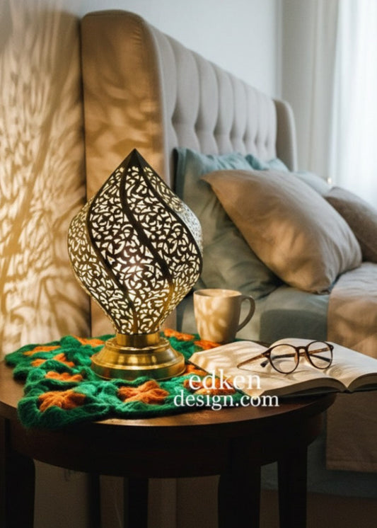 Decorative lamp on a side table with a book and glasses in a cozy living room.