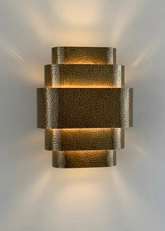 Handmade hammered brass wall lamp with intricate Moroccan patterns.