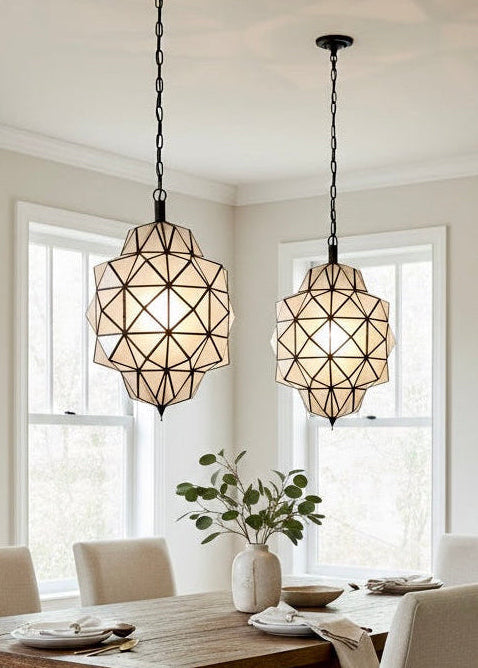 Elegant dining room featuring a wooden table and two handmade Moroccan milky glass and brass pendant lights for a symmetrical look.