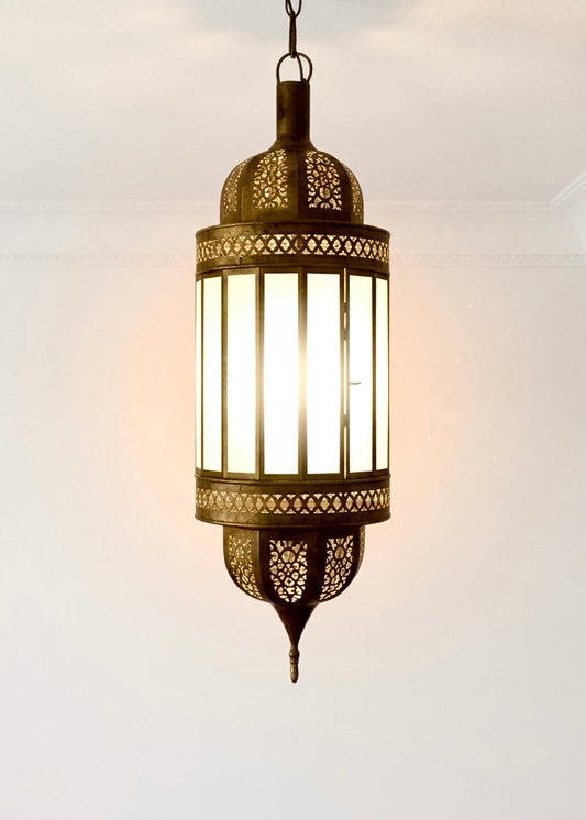 Close-up of a glowing Moroccan brass lantern with white frosted glass, showcasing the warm ambient light and hand-pierced brass details.
