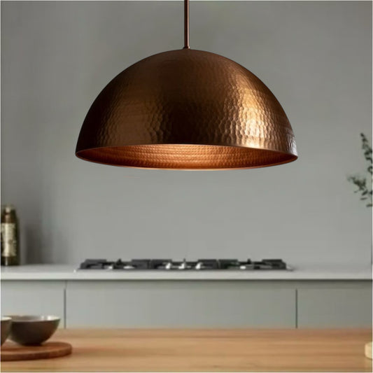 Large hammered copper dome pendant light with a warm metallic glow and modern finish