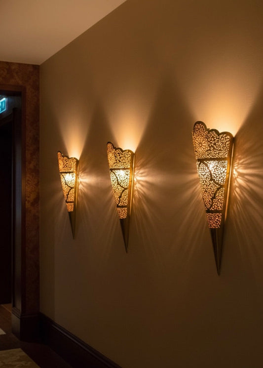Close-up of hand-engraved filigree details on a traditional Moroccan brass sconce.
