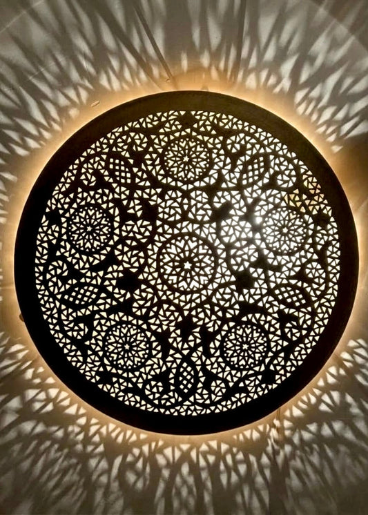 Handcrafted brass Moroccan flush mount ceiling light showing intricate pierced geometric pattern and shadow casting.
