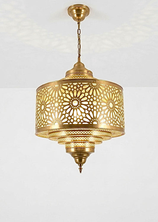 Close-up of a smooth gold brass Moroccan pendant light with intricate handmade filigree patterns and tiered design.