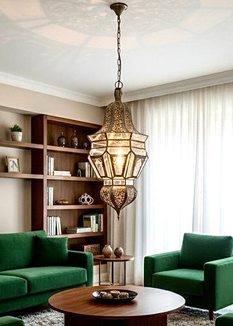 Moroccan handmade brass lantern casting shadows on the ceiling of a stylish living room with green sofas.