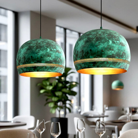 Multiple industrial brass green patina dome ceiling lights installed in a modern restaurant interior with large windows and wooden tables.