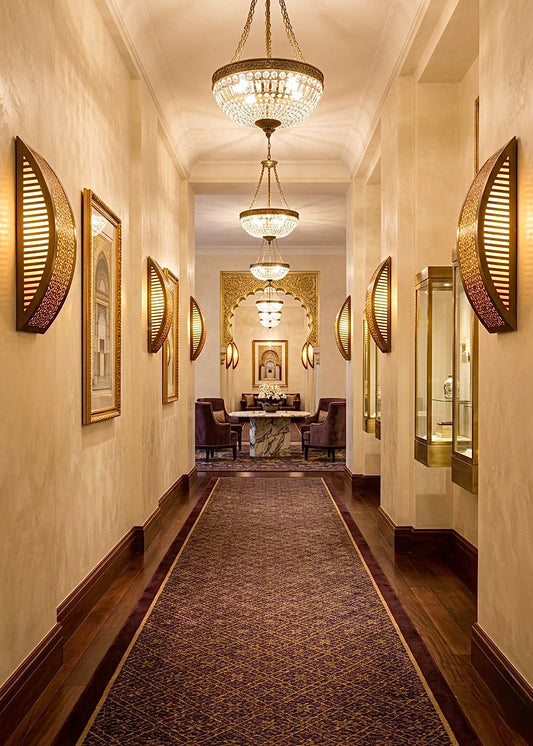 A curved Moroccan brass wall lamp mounted in a minimalist modern interior, providing warm ambient lighting.