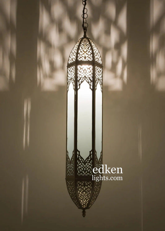 Handmade Moroccan brass and glass pendant lamp casting intricate geometric shadows on the wall.