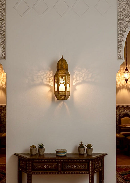 Moroccan brass wall sconce providing ambient lighting in a traditional Riad-style dining room.
