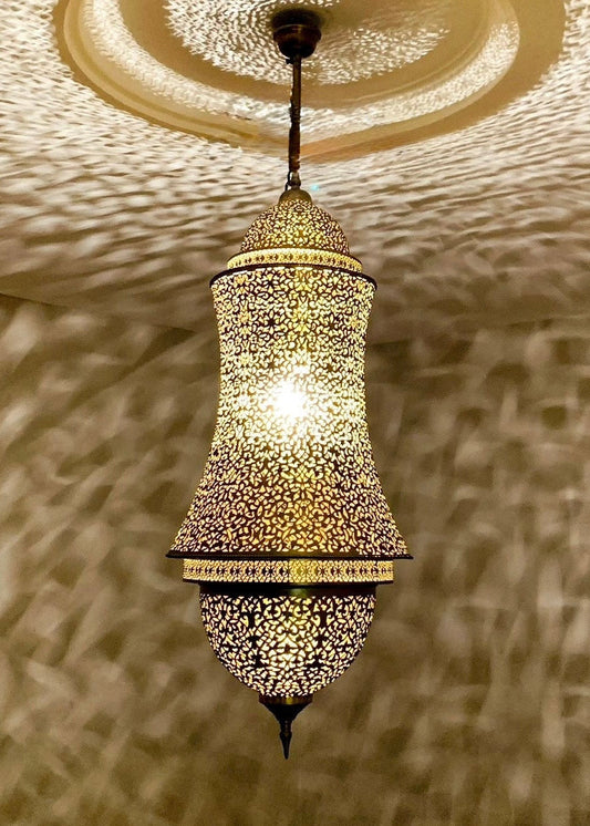 Oriental brass pendant light reflecting intricate artistic shadows on a white ceiling.