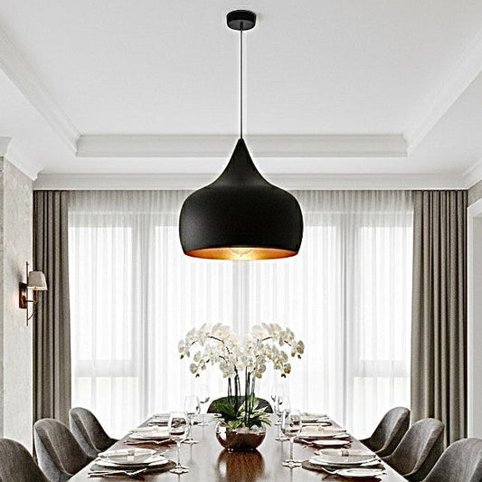 Set of three black and gold brass lamps in a bright open-plan living room with garden view