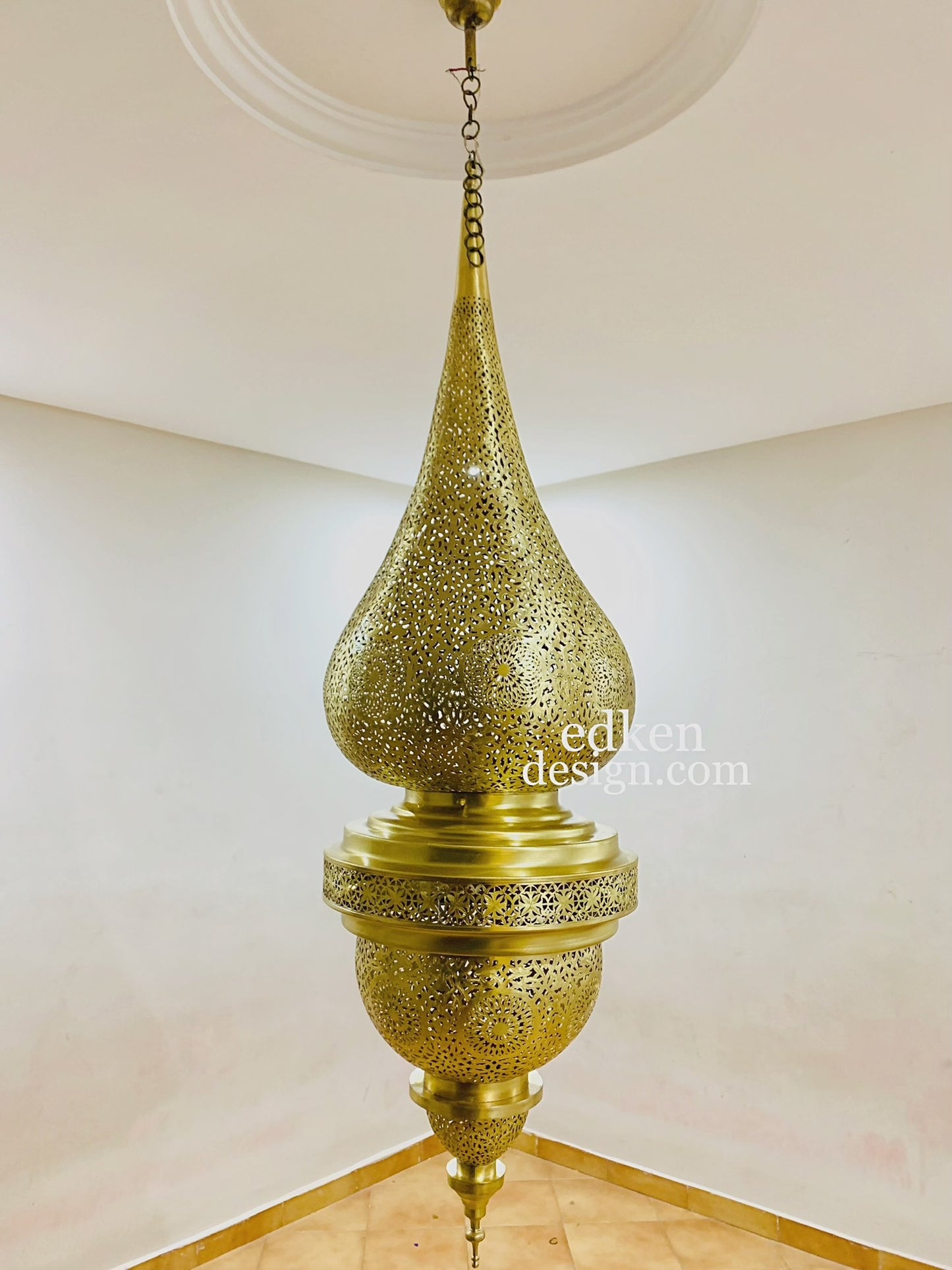 Moroccan hanging light fixture casting beautiful shadow patterns on walls and ceiling.