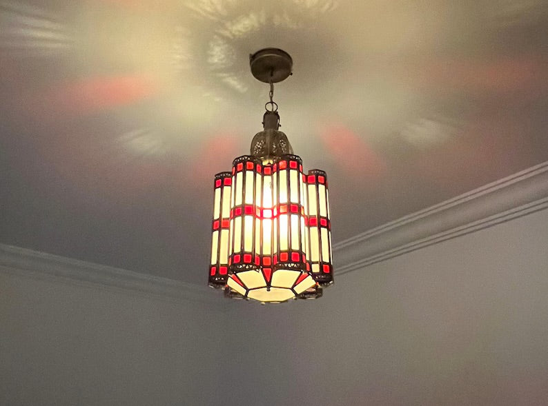 Decorative ceiling light fixture with stained glass design on a ceiling.