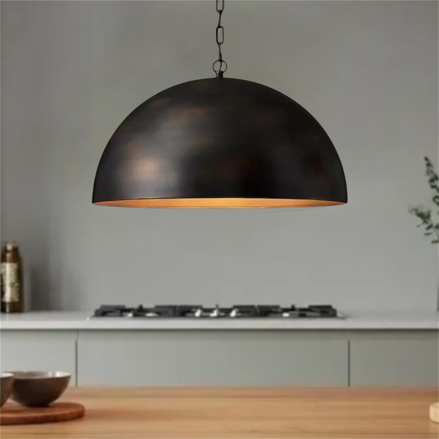 Modern handmade antique brass dome light with a sleek dark exterior and warm interior glow.
