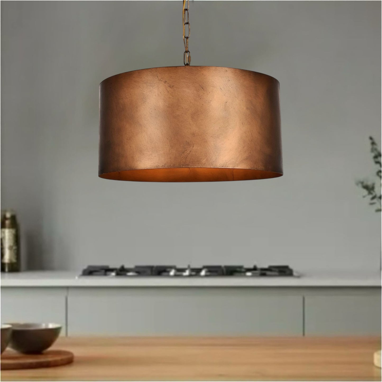 Industrial copper dome pendant light with adjustable chain suspension.