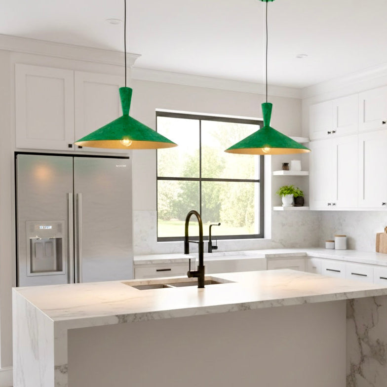 Green patina handmade brass pendant light illuminating a modern white kitchen island