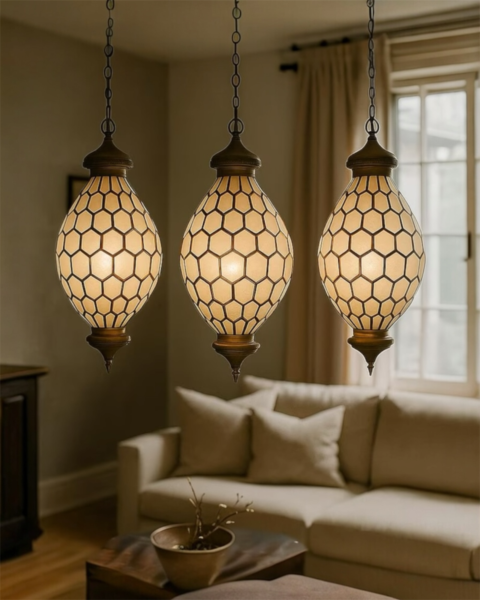 Three hanging pendant lights with a geometric pattern in a living room setting.