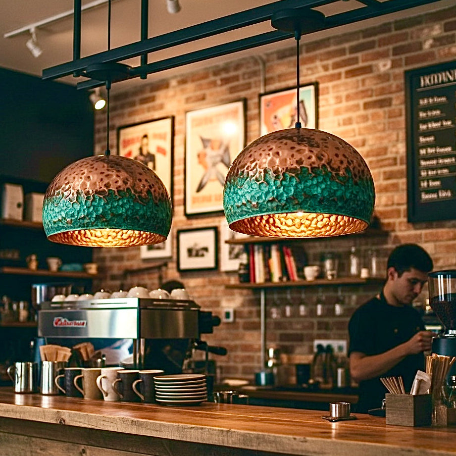 Industrial style hammered copper lighting in a rustic coffee shop with brick walls.