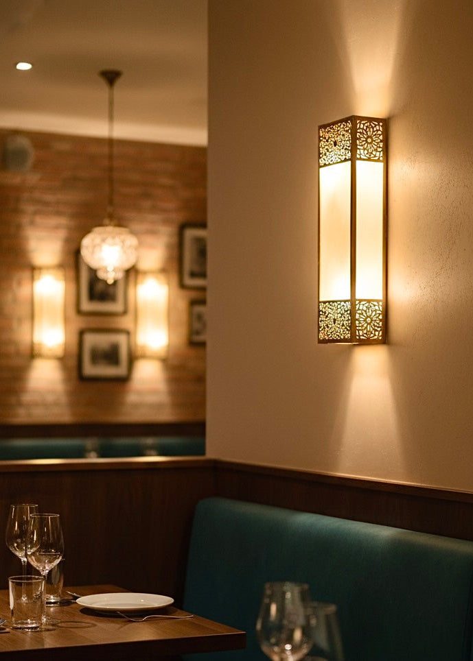Moroccan brass wall light installed in a boho-style bedroom, creating a cozy and exotic atmosphere.