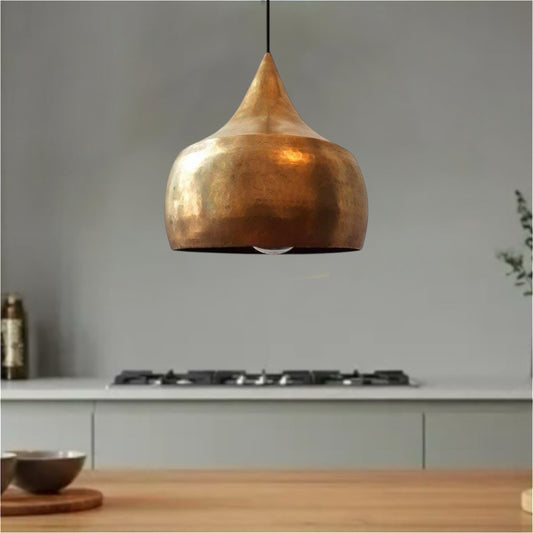 Two modern brass dome lamps hanging over a white marble kitchen island in a bright contemporary home.