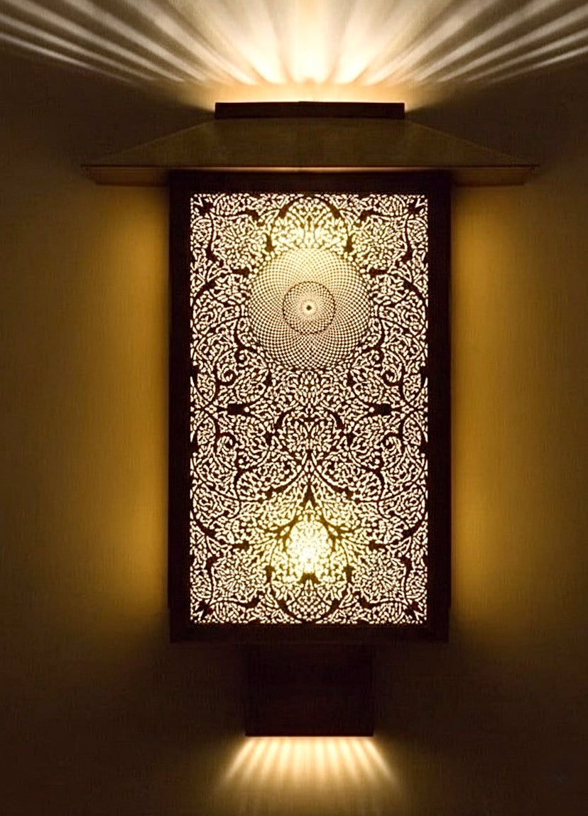 Close-up of fine hand-etched geometric details on a traditional solid brass Moroccan wall sconce.