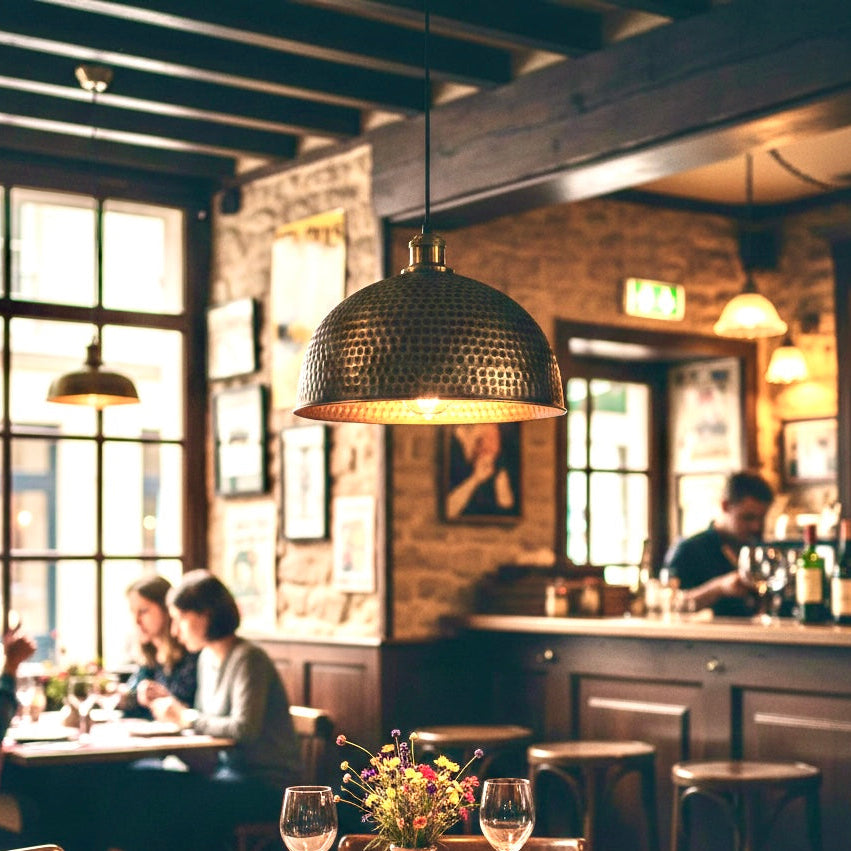Industrial style hammered brass lamps installed in a cozy restaurant bar, perfect for commercial projects.