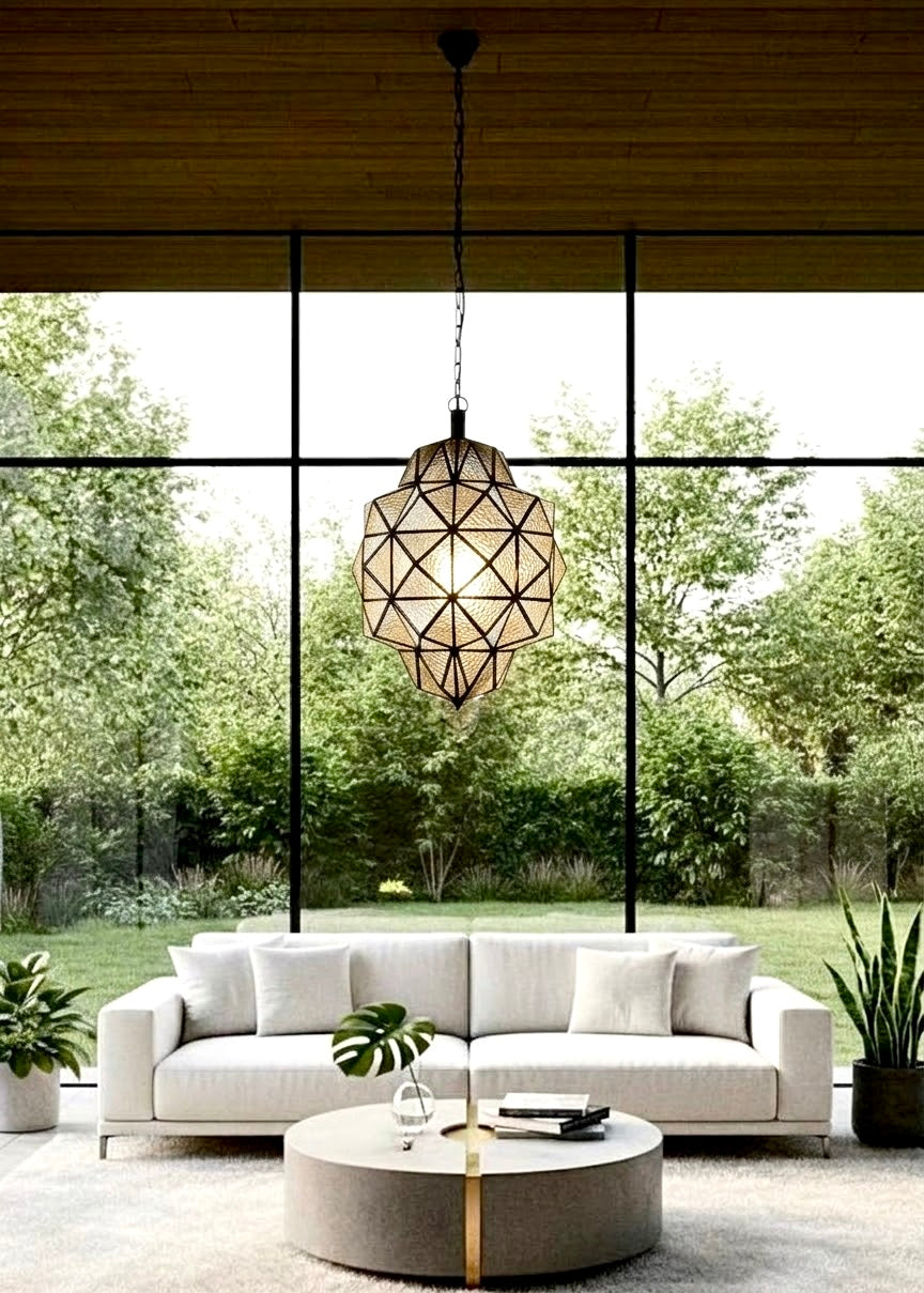 Cozy attic lounge with floor cushions, a low wooden table, and a geometric Moroccan clear glass pendant light casting shadows on a vaulted ceiling.