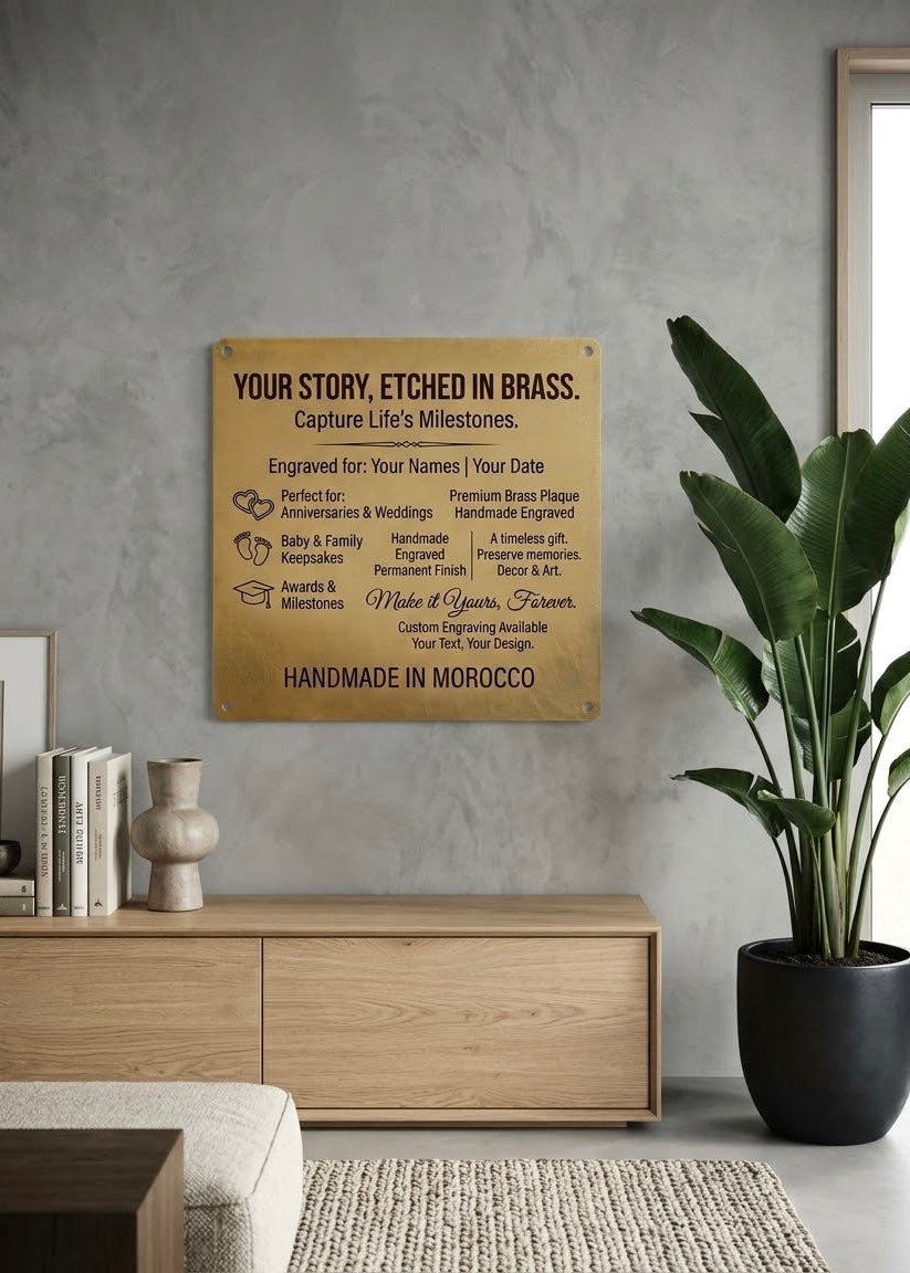 Custom engraved brass commemorative plaque hanging on a grey wall next to a large indoor plant and wooden console.⁠