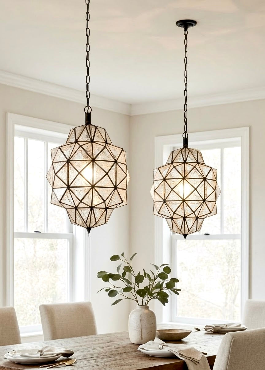 Elegant dining room featuring a wooden table and two handmade Moroccan clear textured/hammered glass and brass pendant lights for a symmetrical look.