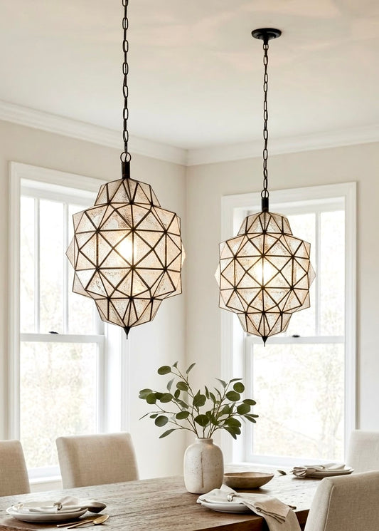 Elegant dining room featuring a wooden table and two handmade Moroccan clear textured/hammered glass and brass pendant lights for a symmetrical look.