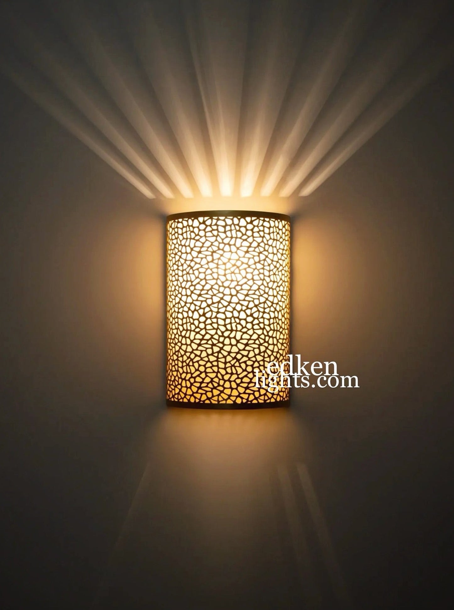 Close-up of hand-pierced floral details on Moroccan brass lighting.