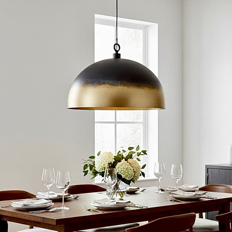 Close-up of the warm gold interior of a matte black modern brass dome lamp.