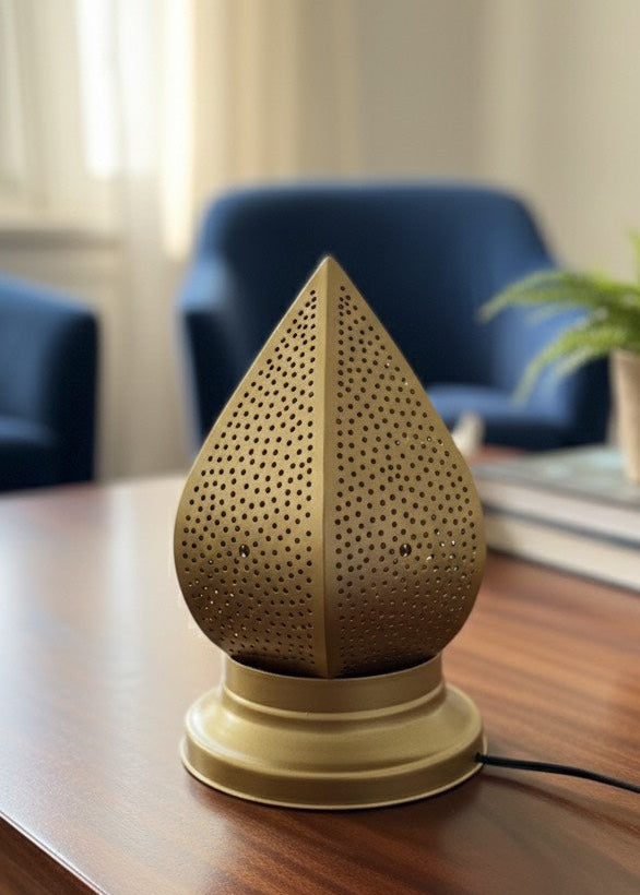 Close-up of a gold-finished Moroccan table lamp showing intricate hand-drilled holes and artisanal brass craftsmanship.