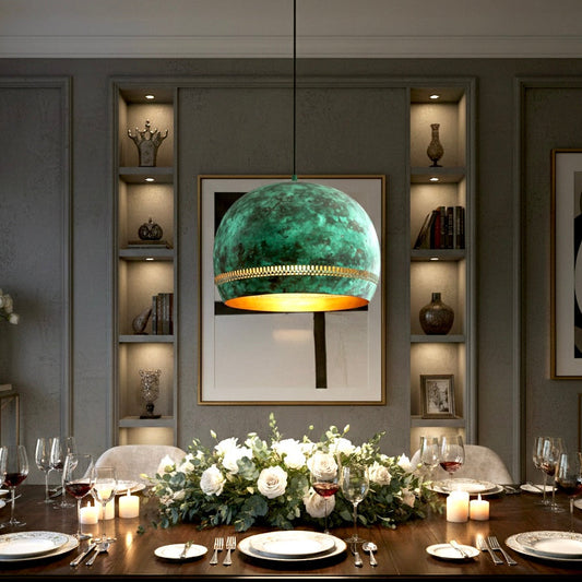 Large green patina copper dome lamp with gold interior centered over a formal dining table set with white roses and candles.