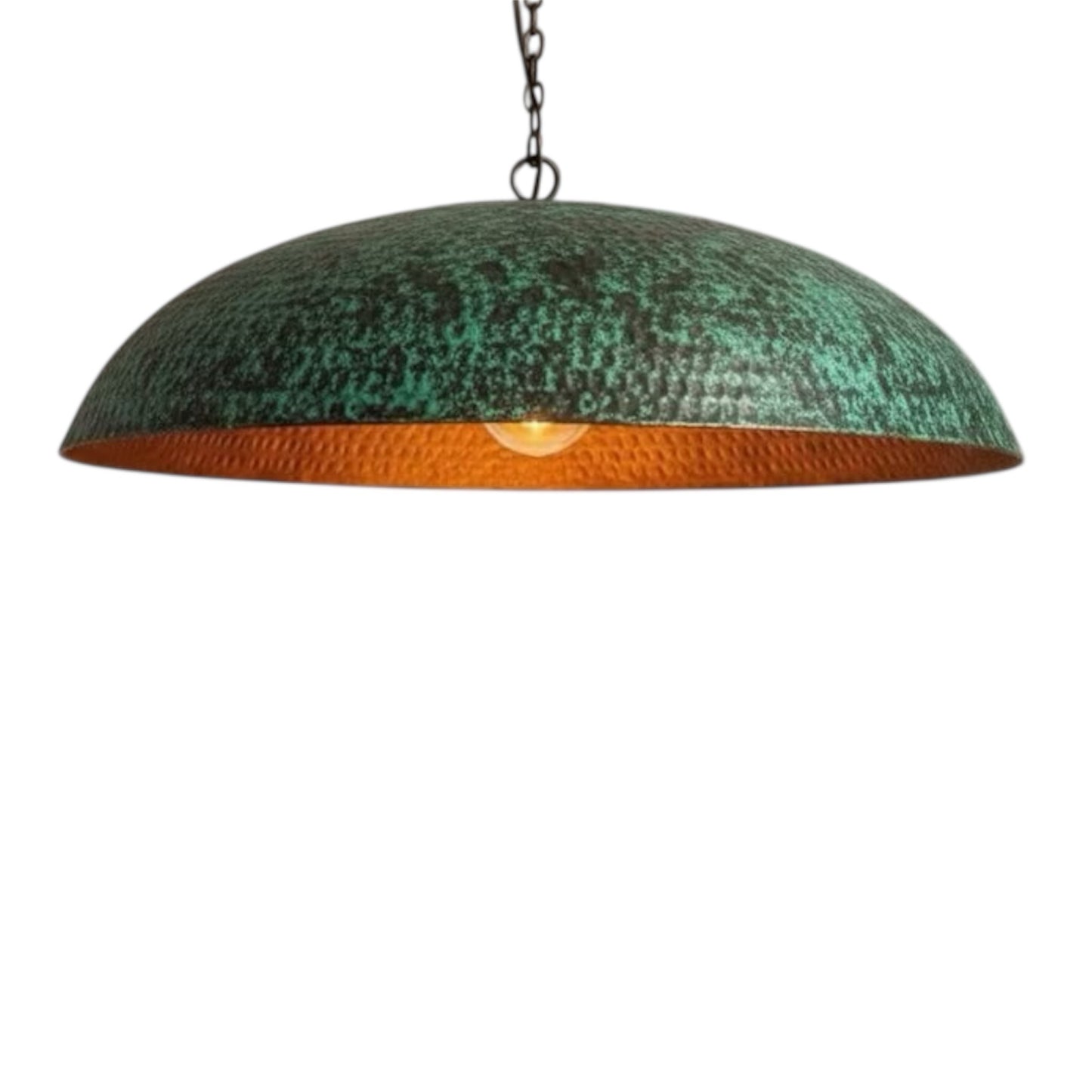 large dome-shaped hammered copper pendant light with a green verdigris patina exterior and a warm glowing copper interior.