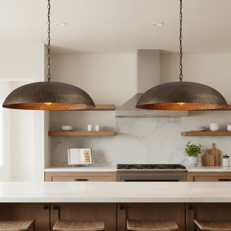 Close-up detail of the hand-hammered surface on an antique brass light fixture.