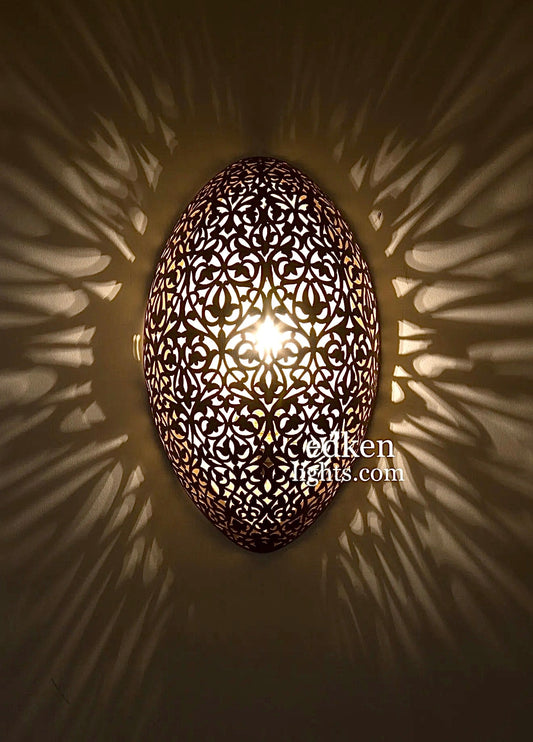 Close-up shot of a hand-etched Moroccan wall lamp showcasing intricate traditional brass patterns and craftsmanship.