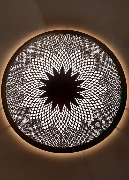 Detailed view of a Moroccan handmade brass wall sconce featuring a traditional star-shaped sunburst pattern