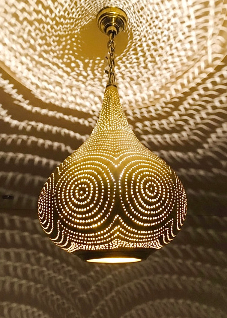 Antique brass Moroccan pendant light shown in daylight, highlighting the natural metallic finish and teardrop shape.