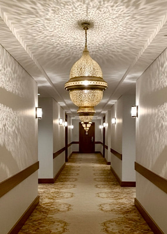 Close-up of the intricate hand-etched design on a large brass hanging pendant.