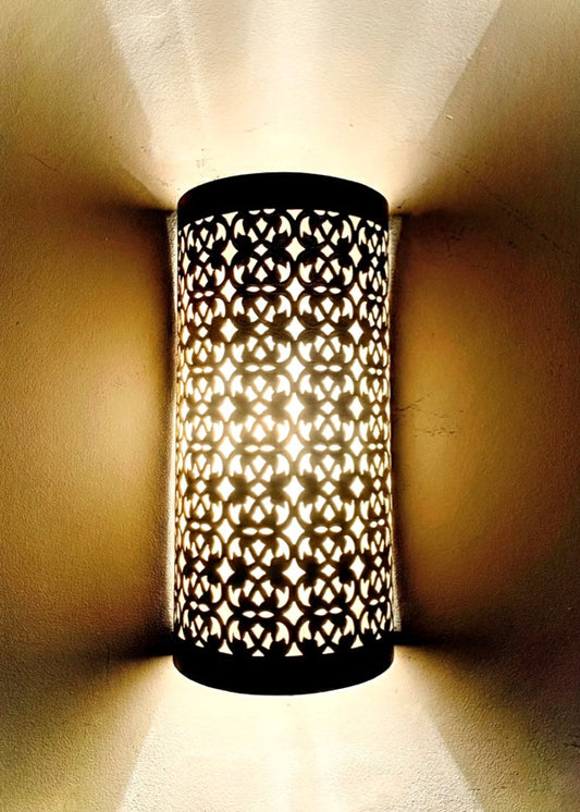Close-up of a handcrafted brass wall sconce showing the high-quality engraving and artisanal metalwork details.