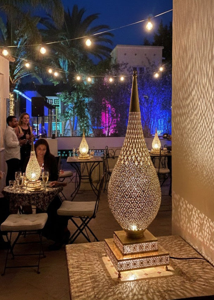 A handmade, bulb-shaped Moroccan brass table lamp shown in a neutral setting, off, displaying metalwork and base.