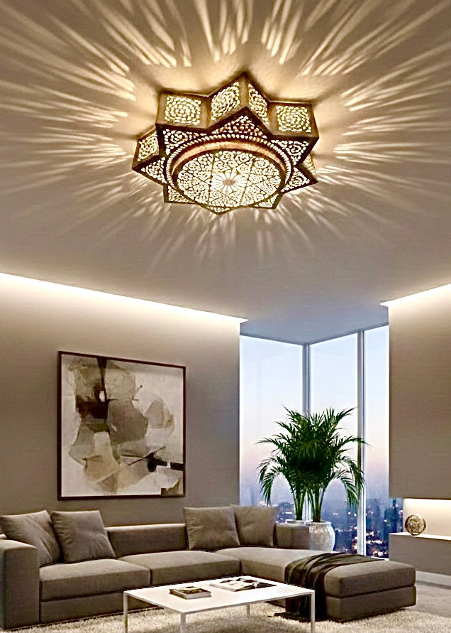 Large handmade Moroccan brass flush mount ceiling light casting geometric shadow patterns in a modern neutral living room.