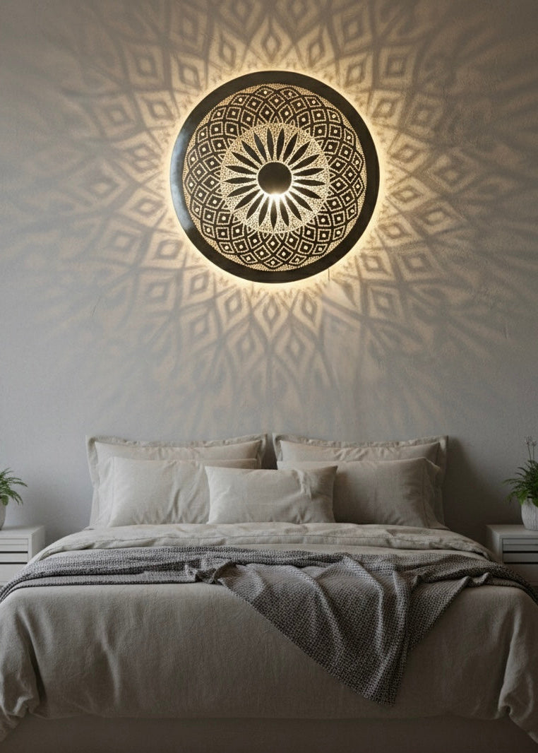 Close-up of the hand-carved geometric cutouts and craftsmanship on an authentic Moroccan brass wall sconce.