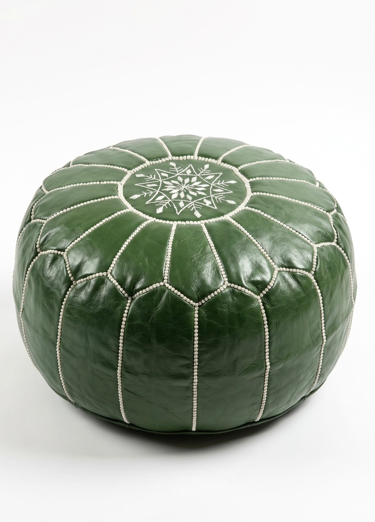 Side angle studio view of a handmade olive green Moroccan leather ottoman footstool featuring white embroidery details.