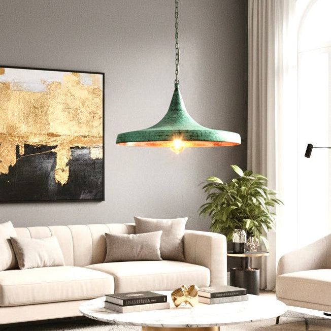 Close up of handmade green patina copper pendant light hanging over a marble coffee table in a modern living room.