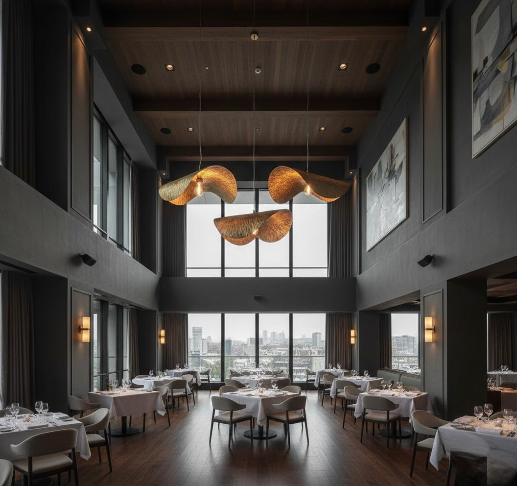 Dramatic gold leaf pendant lights in a high-ceiling luxury restaurant with large windows and city view.