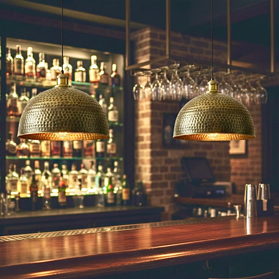 Elegant bronze finished brass lamps hanging over a dark wood bar counter, available for global distribution.