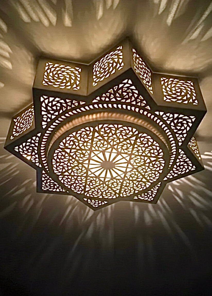 Close-up of 100% handmade Moroccan brass lamp showing detailed star geometric patterns and traditional craftsmanship.